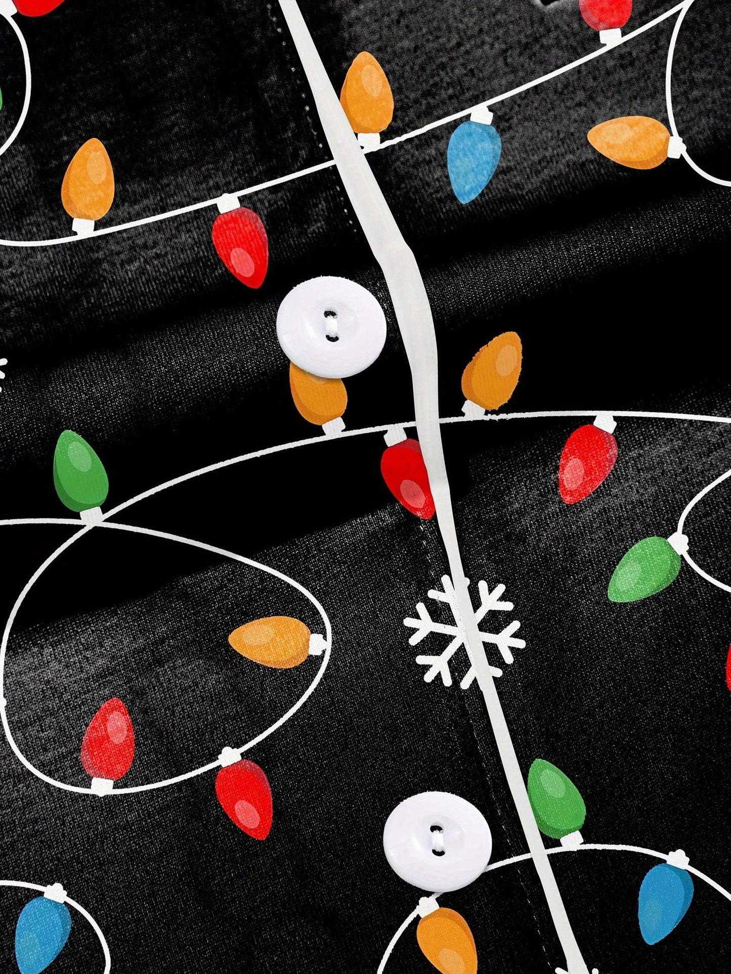 Black short-sleeve women’s pajama set with multicolor string-light and snowflake print — button-up top and elastic waist shorts with contrast piping
