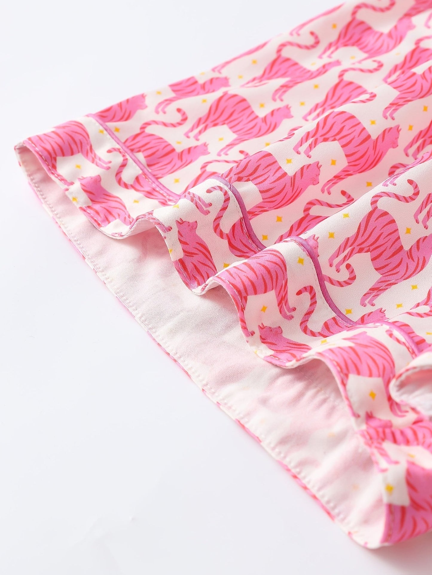 Pink satin-look short-sleeve pajama set with repeating zebra print, piped trim and elastic waist shorts in 95% Polyester 5% Elastane — silky stretch travel-ready loungewear