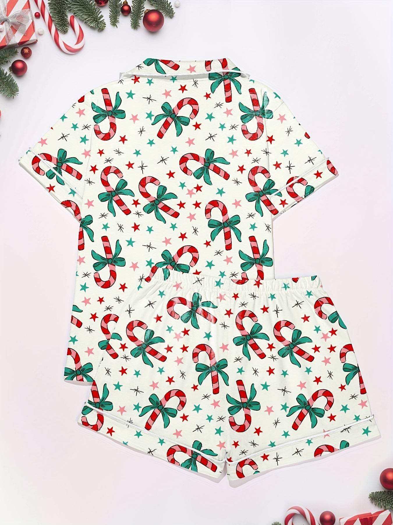 Cream cotton pajama set with candy‑cane and green bow print — short‑sleeve button top and elastic waist shorts with piping