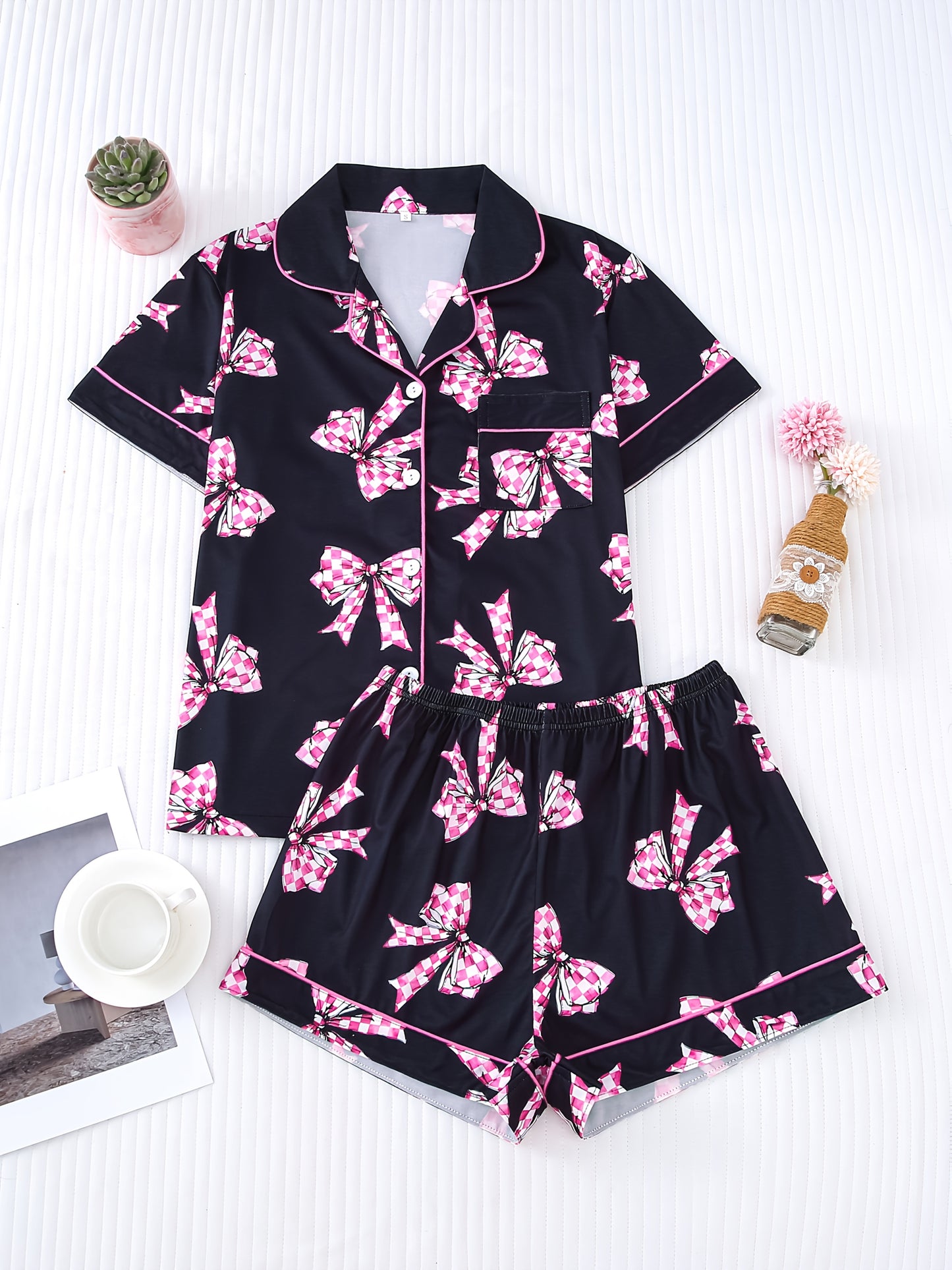 Black satin-look pajama set with pink-check bow print, piped trim, short sleeve button top and elastic waist shorts in silky stretch fabric — 95% Polyester/5% Elastane