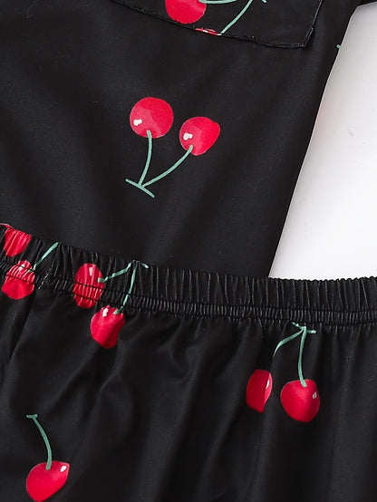 Black satin-look short-sleeve pajama set with red cherry print, piped trim, chest pocket and elastic waist shorts in 95% Polyester 5% Elastane