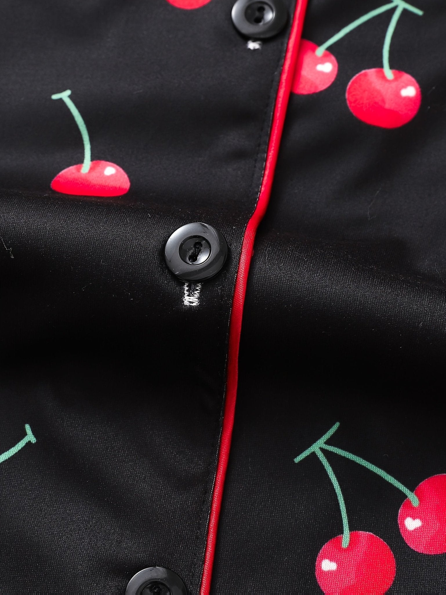Black satin-look short-sleeve pajama set with red cherry print, piped trim, chest pocket and elastic waist shorts in 95% Polyester 5% Elastane
