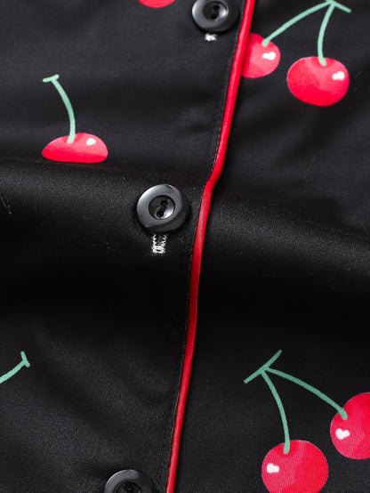Black satin-look short-sleeve pajama set with red cherry print, piped trim, chest pocket and elastic waist shorts in 95% Polyester 5% Elastane