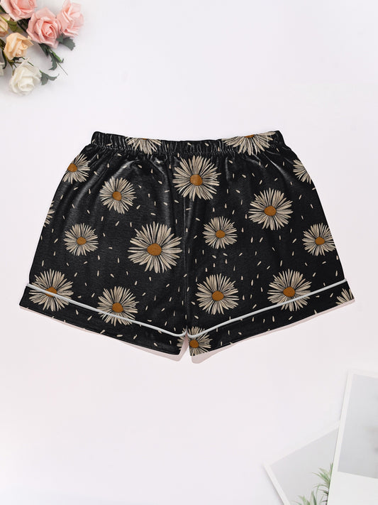 Black short-sleeve modal pajama set with cream daisy print — button-up top and elastic waist shorts with white piping