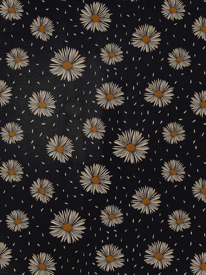 Black short-sleeve modal pajama set with cream daisy print — button-up top and elastic waist shorts with white piping