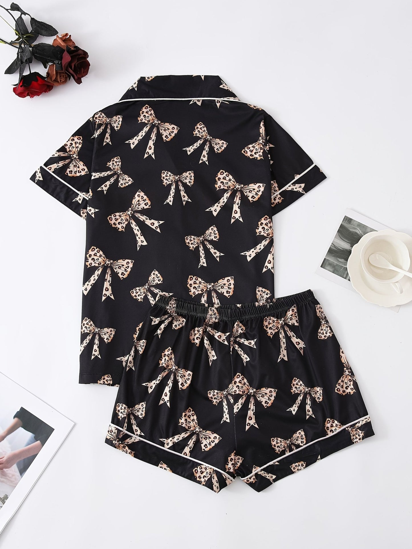Black satin-look short-sleeve pajama set with beige leopard bow print, piped trim, chest pocket and elastic waist shorts in 95% Polyester 5% Elastane