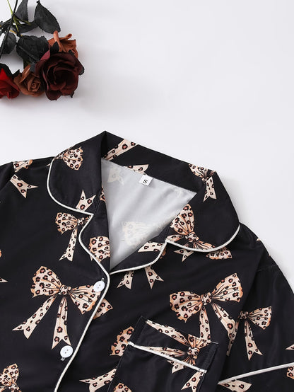 Black satin-look short-sleeve pajama set with beige leopard bow print, piped trim, chest pocket and elastic waist shorts in 95% Polyester 5% Elastane