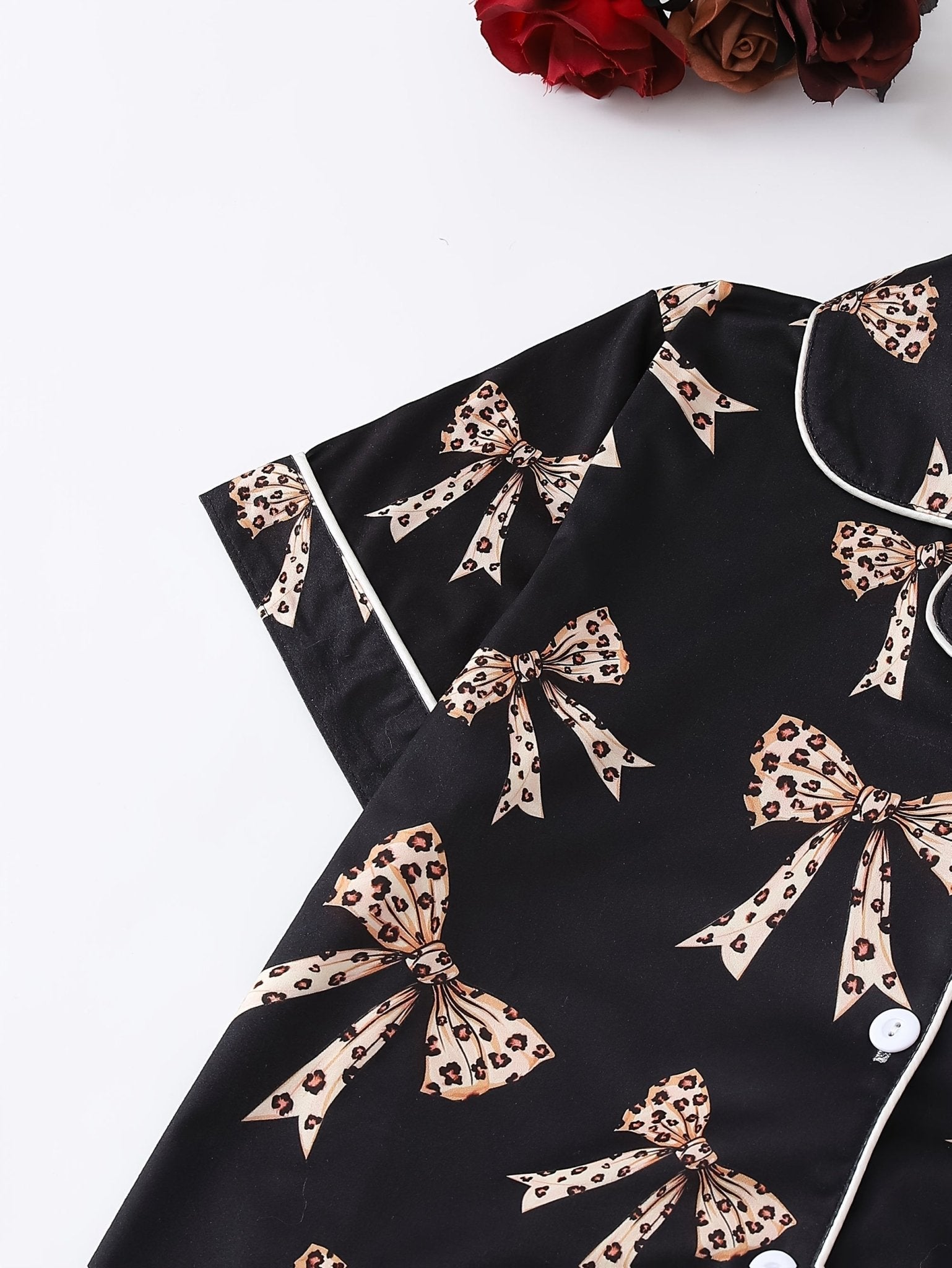 Black satin-look short-sleeve pajama set with beige leopard bow print, piped trim, chest pocket and elastic waist shorts in 95% Polyester 5% Elastane