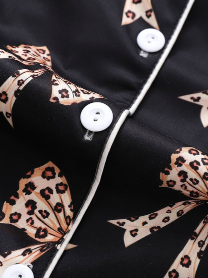 Black satin-look short-sleeve pajama set with beige leopard bow print, piped trim, chest pocket and elastic waist shorts in 95% Polyester 5% Elastane