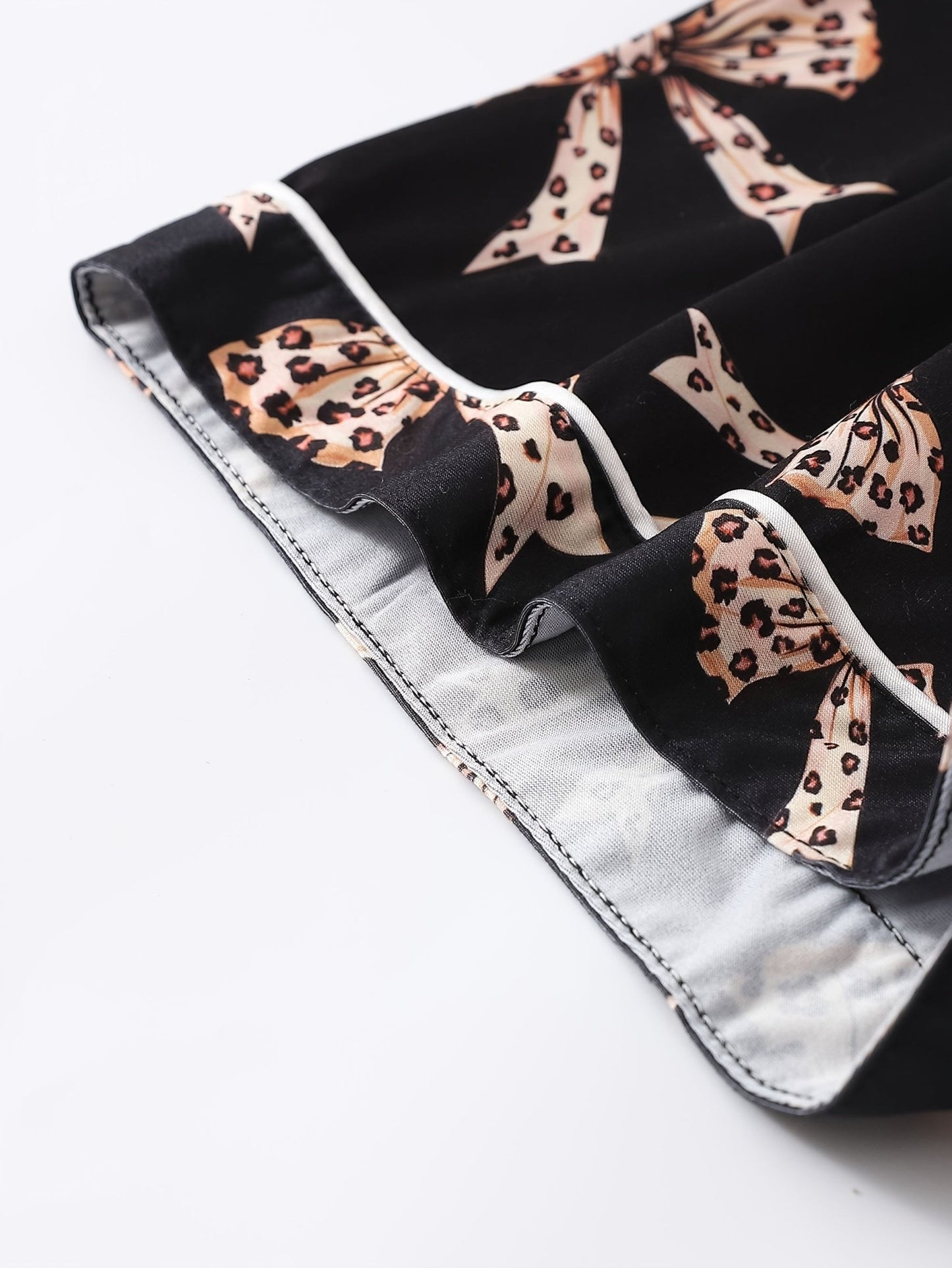 Black satin-look short-sleeve pajama set with beige leopard bow print, piped trim, chest pocket and elastic waist shorts in 95% Polyester 5% Elastane