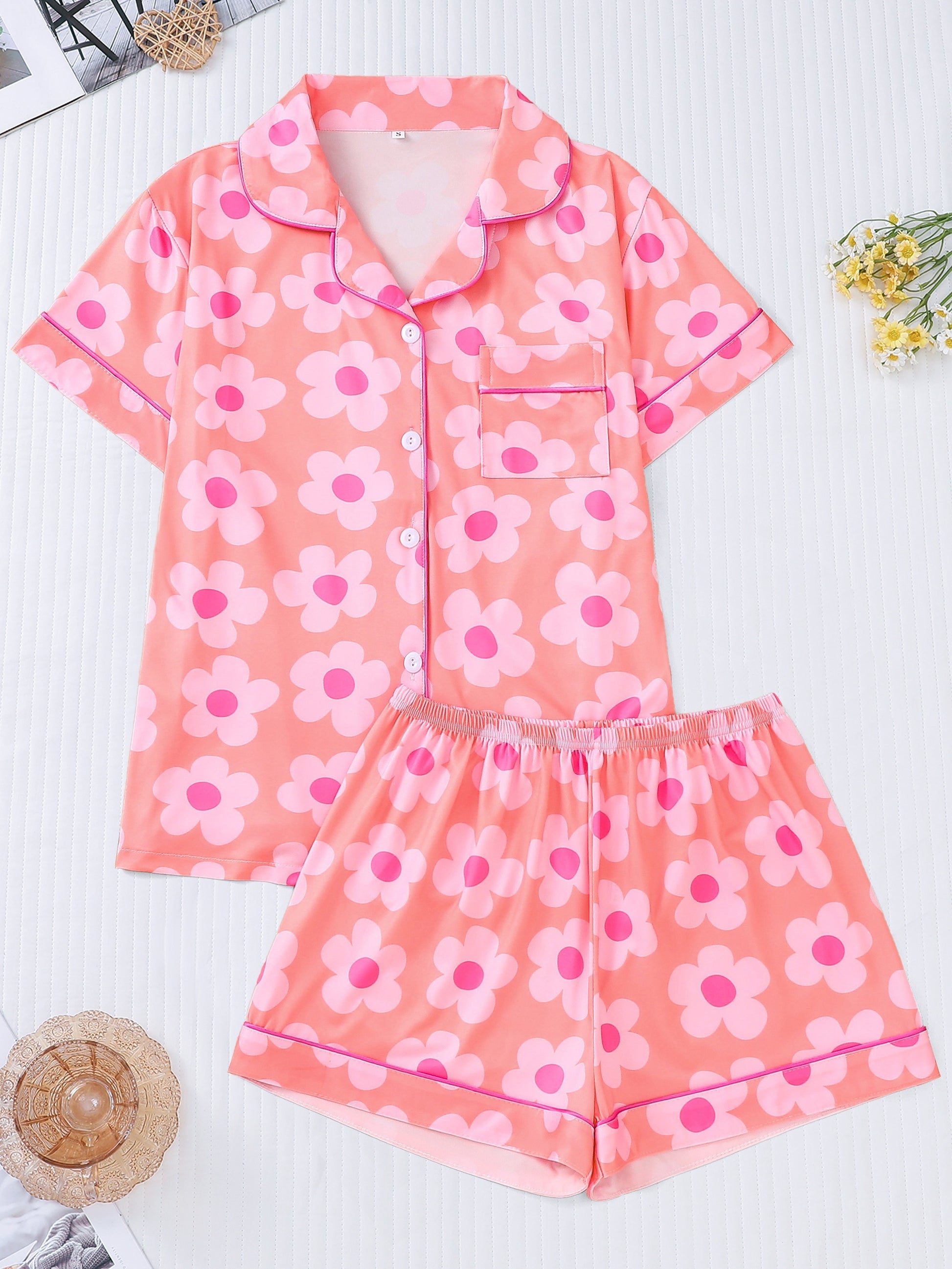 Powder satin-look pajama set with white daisy print — short-sleeve button-up top with chest pocket and elastic waist shorts, 95% Polyester/5% Elastane