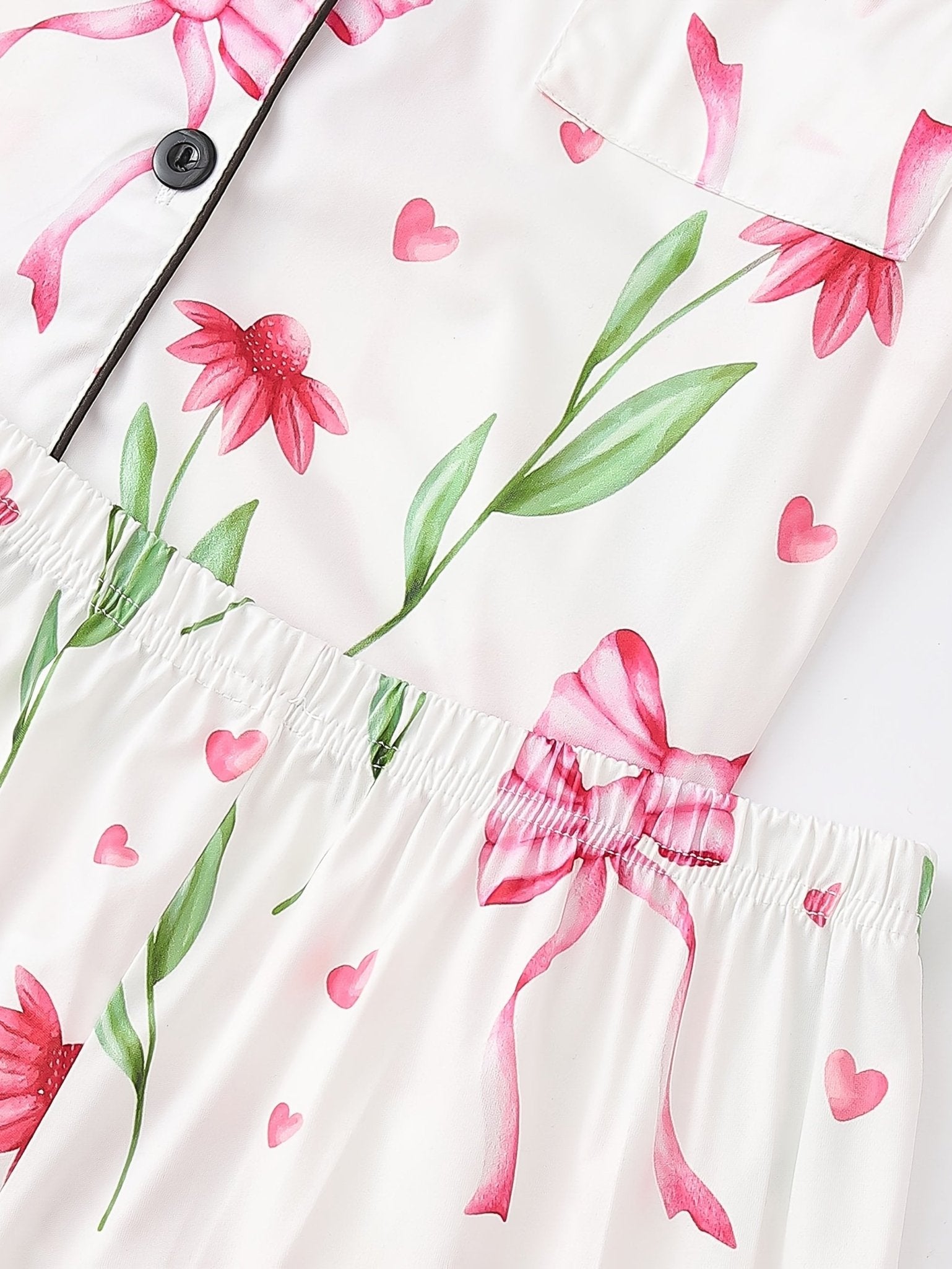 White satin-look short-sleeve pajama set with pink bow and floral print, piped trim, chest pocket and elastic waist shorts in 95% Polyester 5% Elastane — travel-ready silky stretch loungewear