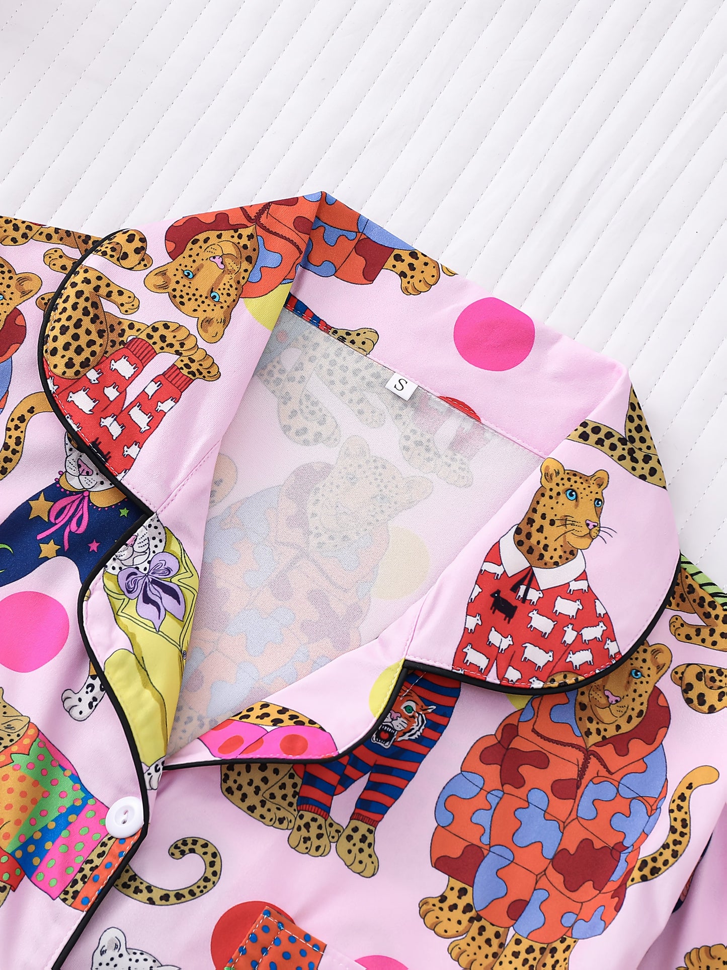 Blush pink satin-look pajama set with colorful leopard illustrations and polka dots — short-sleeve button-up top with chest pocket and elastic waist shorts, 95% Polyester/5% Elastane