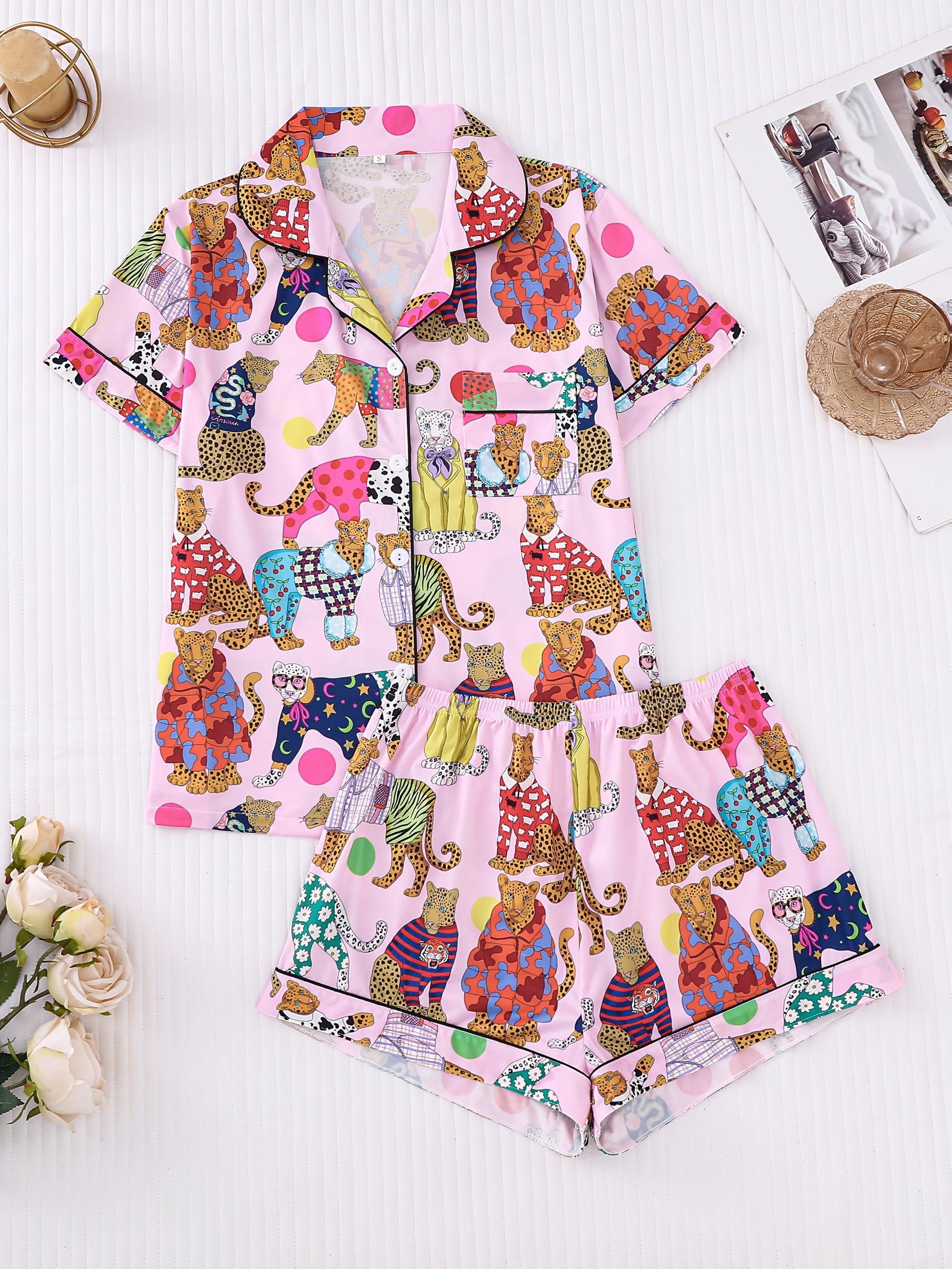 Blush pink satin-look pajama set with colorful leopard illustrations and polka dots — short-sleeve button-up top with chest pocket and elastic waist shorts, 95% Polyester/5% Elastane