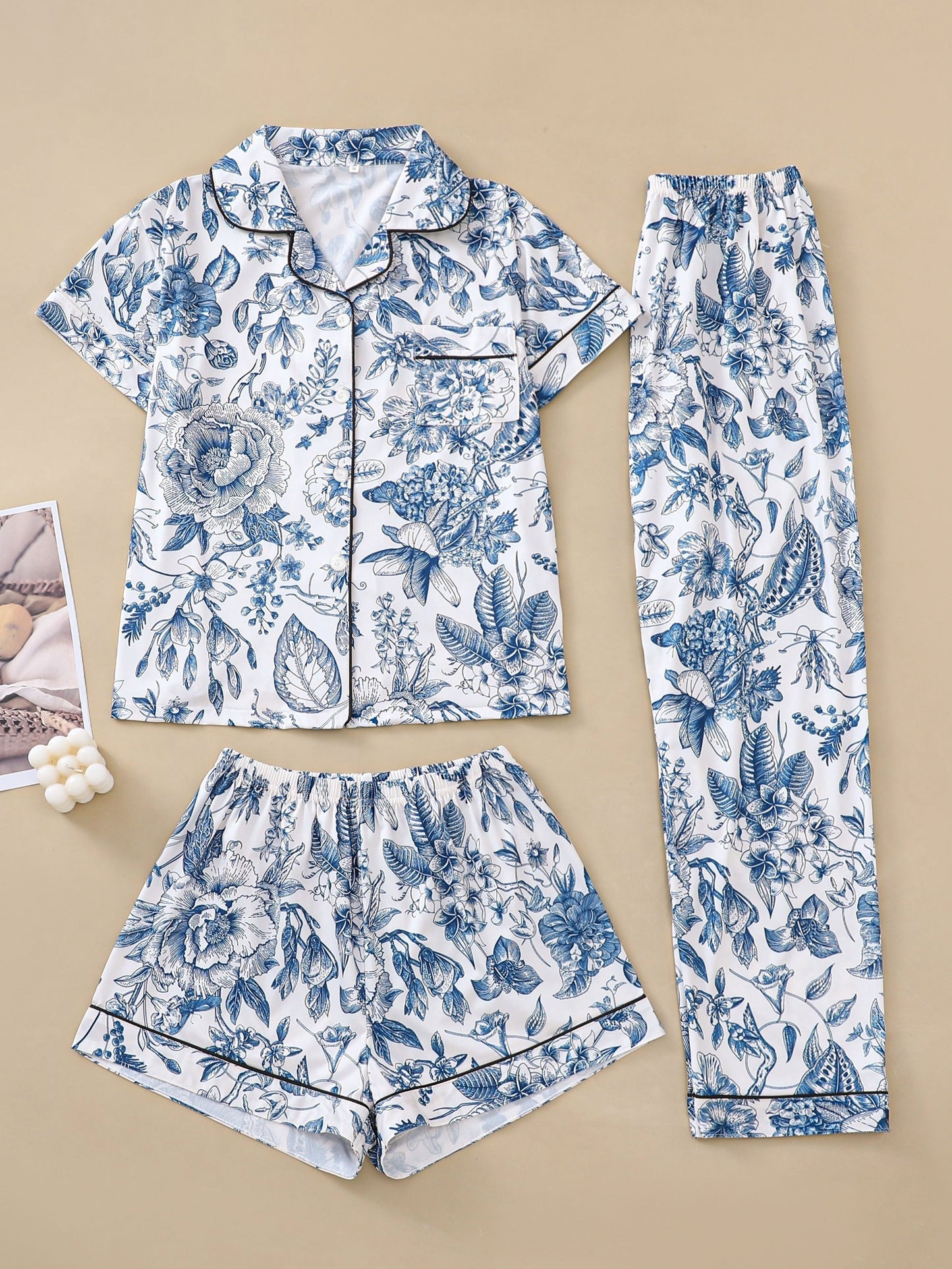 White satin-look pajama set with pink toile floral print — short-sleeve button-up top with chest pocket, elastic waist shorts and full-length pants, 95% Polyester/5% Elastane