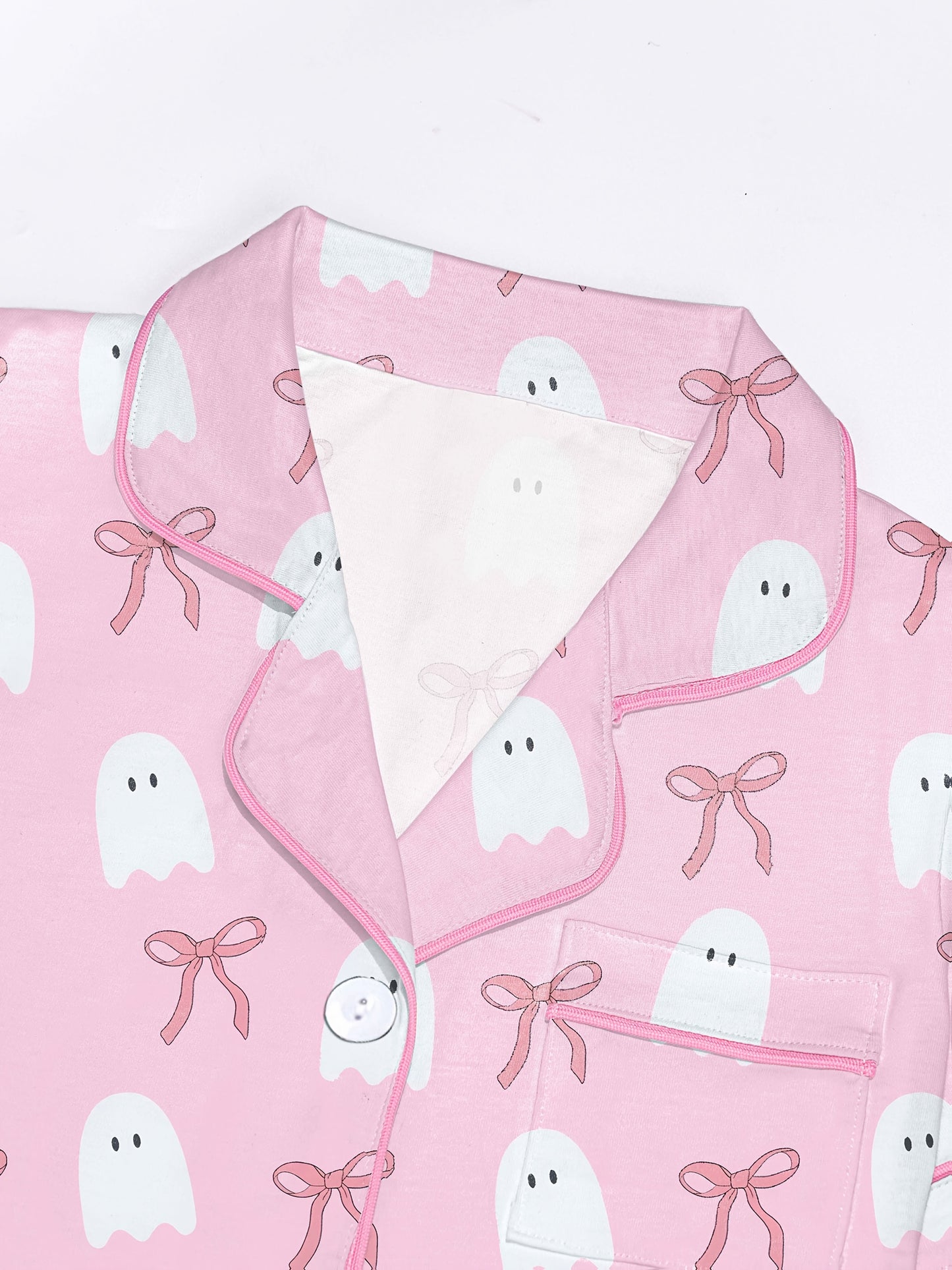 Pink cotton pajama set with white ghost and ribbon print — short sleeve notch collar top and elastic waist shorts
