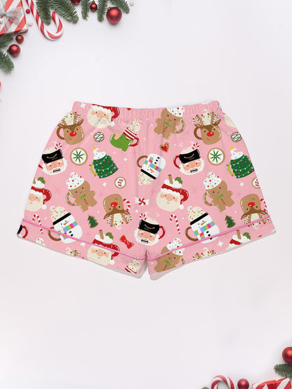 Pink satin‑look sleep shorts with playful Christmas icons — Santa mugs, snowmen, gingerbread, reindeer and candy — elastic waist and white piping