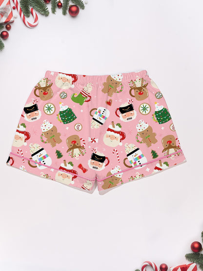 Pink satin‑look sleep shorts with playful Christmas icons — Santa mugs, snowmen, gingerbread, reindeer and candy — elastic waist and white piping
