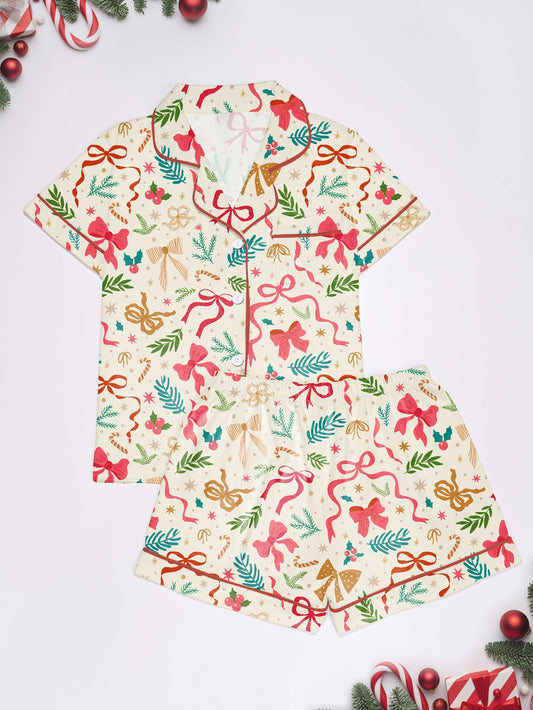 Cream cotton short-sleeve pajama set with pink and gold ribbon and greenery print — button-up top and elastic waist shorts with contrast piping