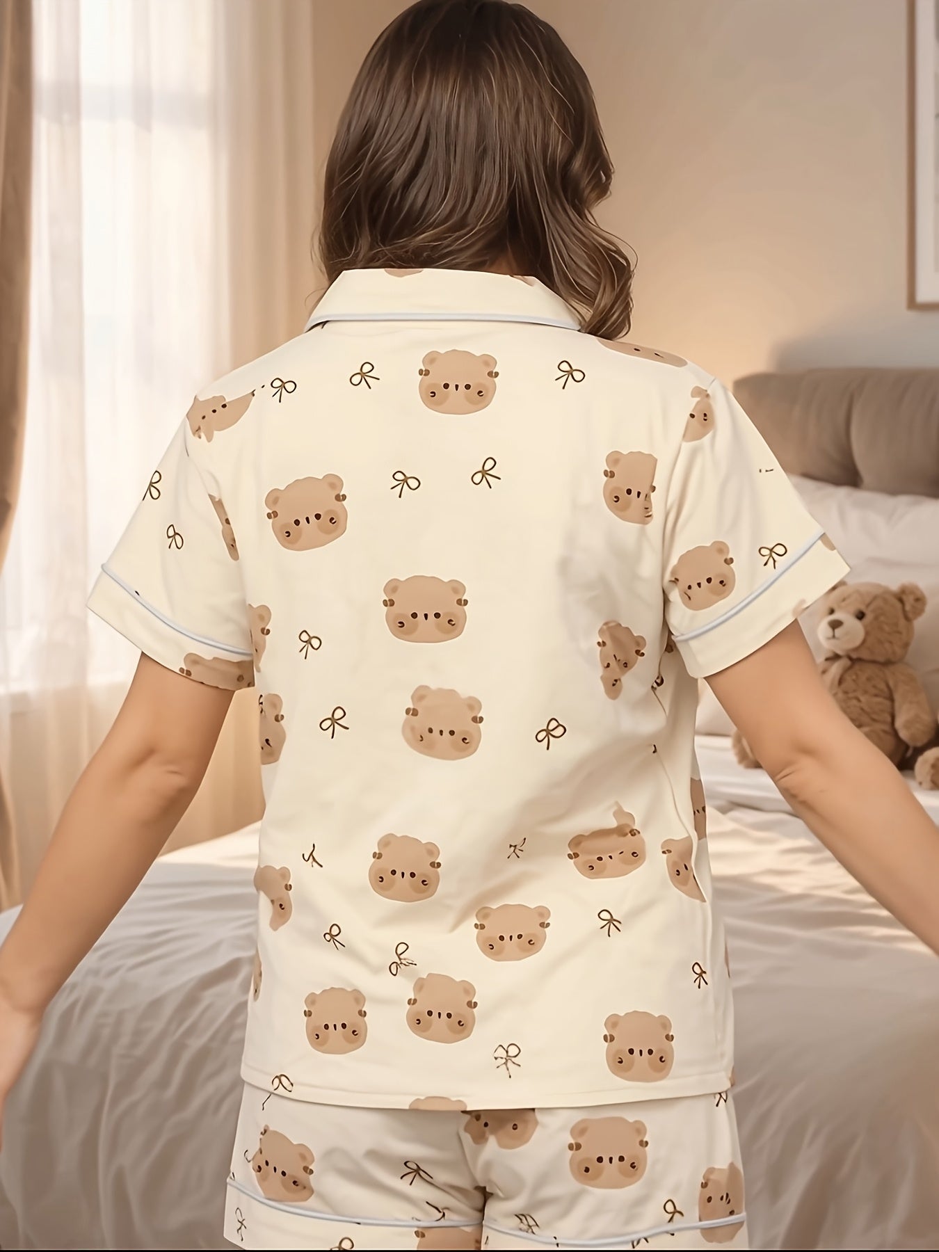 Cream short‑sleeve modal pajama set with teddy face and bow print — button‑up top and elastic waist shorts with piping