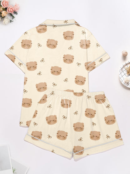 Cream short‑sleeve modal pajama set with teddy face and bow print — button‑up top and elastic waist shorts with piping