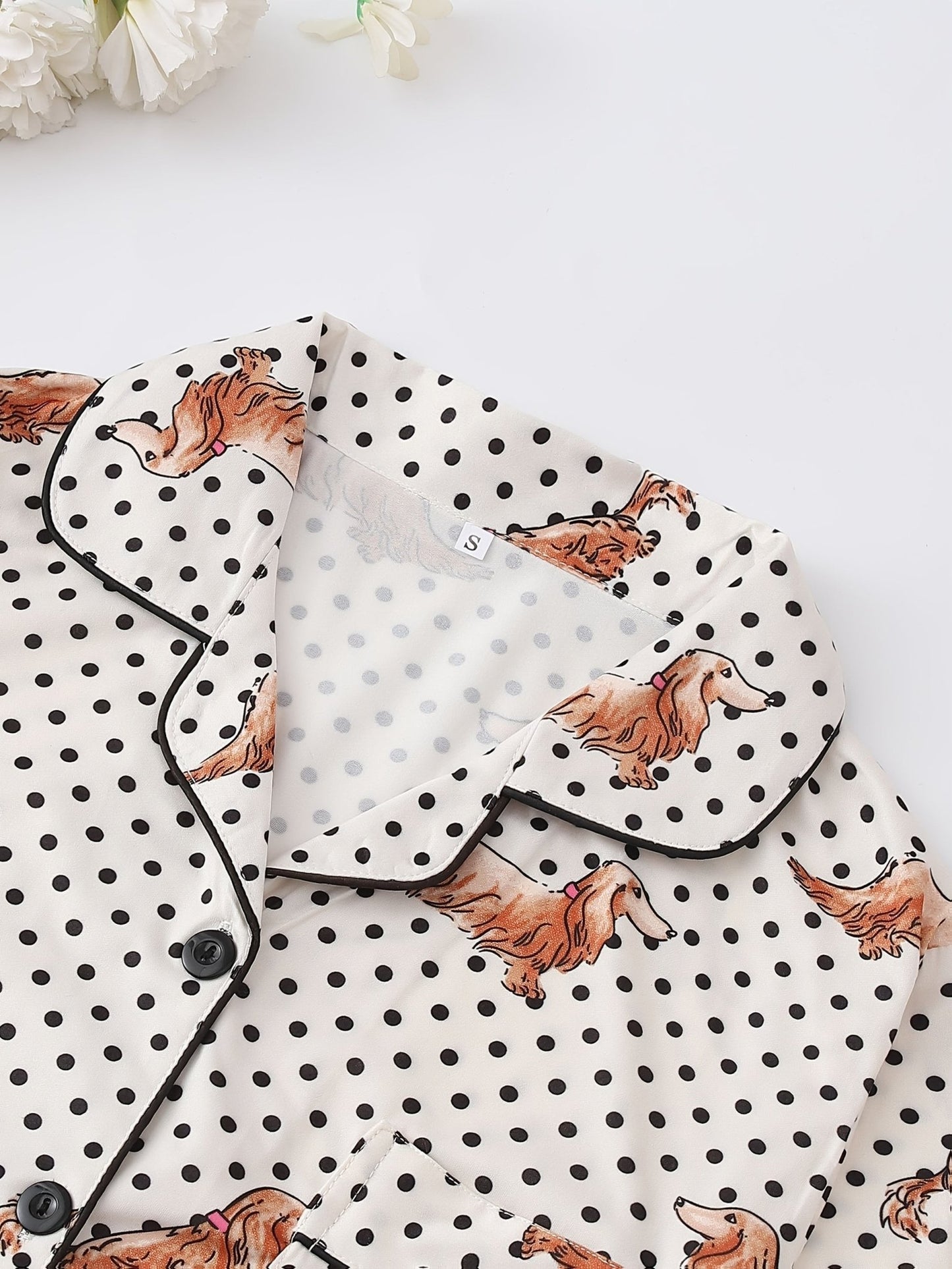 Cream and black polka dot satin-look pajama set with dachshund print, piped trim, chest pocket and elastic waist shorts in 95% Polyester 5% Elastane — silky stretch travel-ready loungewear