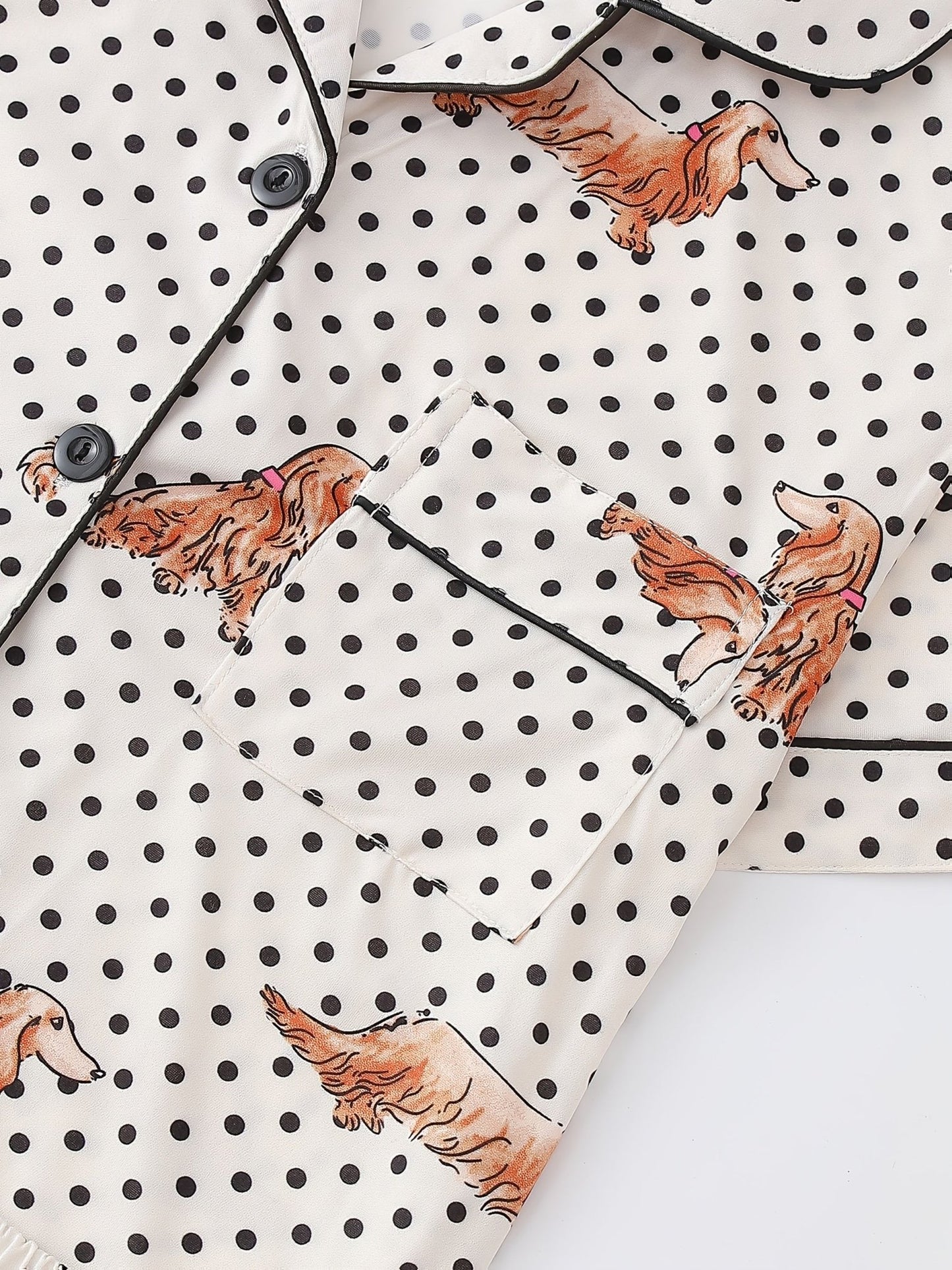 Cream and black polka dot satin-look pajama set with dachshund print, piped trim, chest pocket and elastic waist shorts in 95% Polyester 5% Elastane — silky stretch travel-ready loungewear