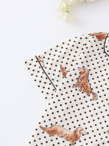 Cream and black polka dot satin-look pajama set with dachshund print, piped trim, chest pocket and elastic waist shorts in 95% Polyester 5% Elastane — silky stretch travel-ready loungewear