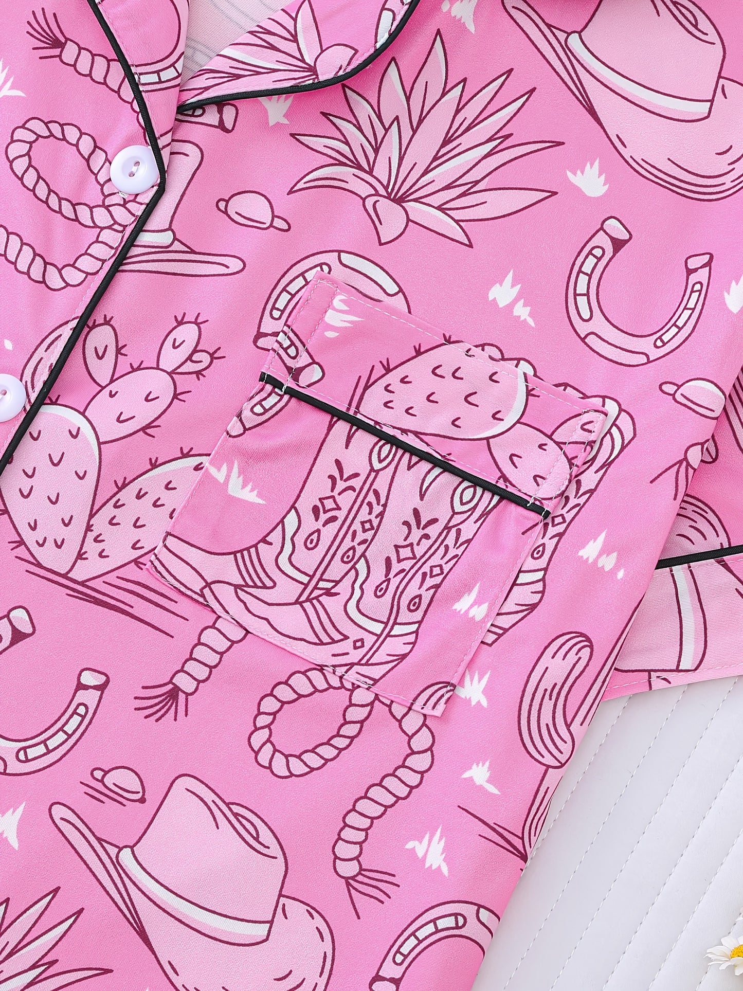 Bubblegum pink satin-look short pajama set with cowboy boots, hats and cactus print — button-up short-sleeve top with chest pocket and elastic waist shorts, 95% Polyester/5% Elastane