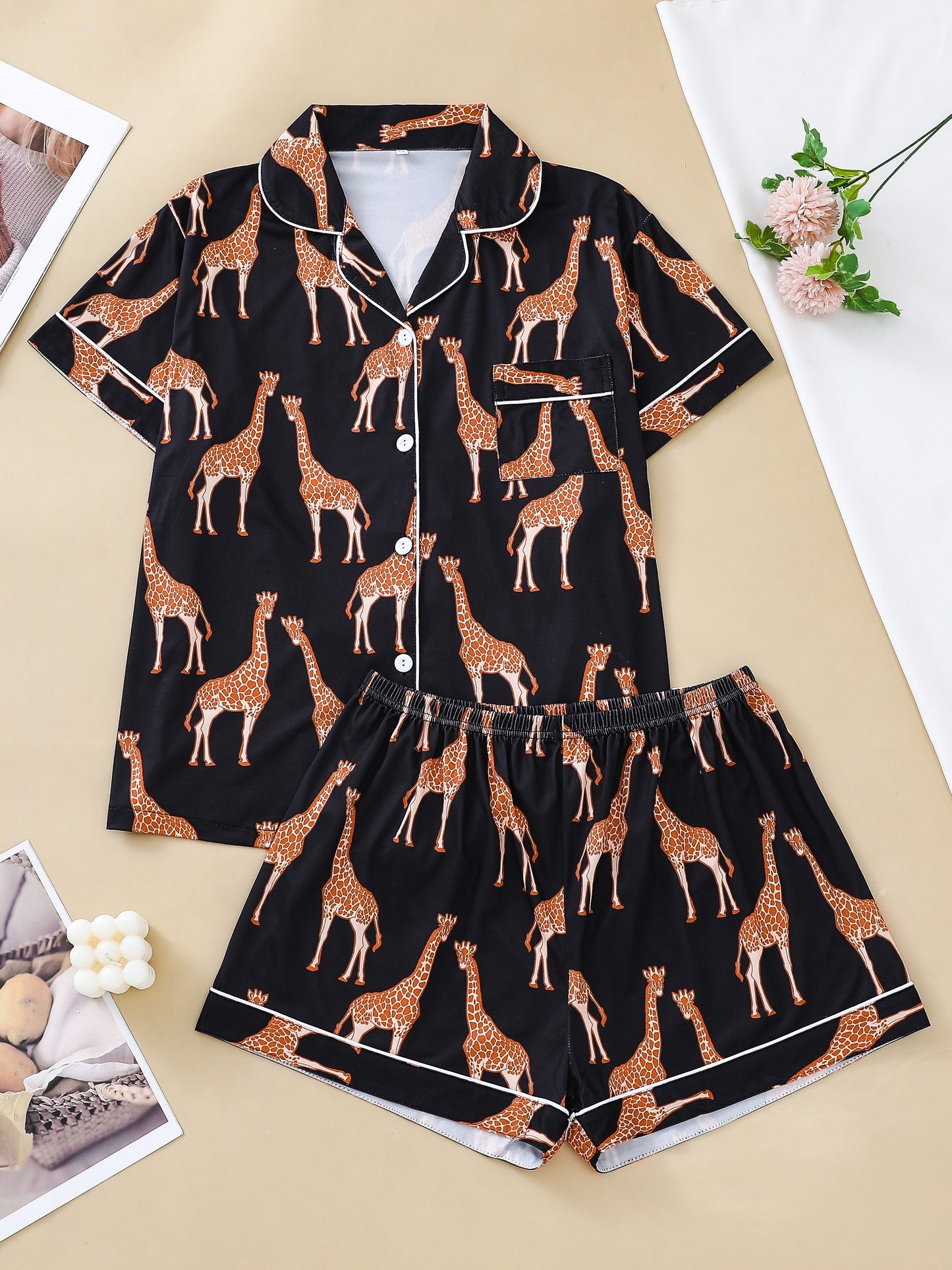 Hot satin-look pajama set with black-and-white giraffe print — short-sleeve button-up top with chest pocket and elastic waist shorts, 95% Polyester/5% Elastane