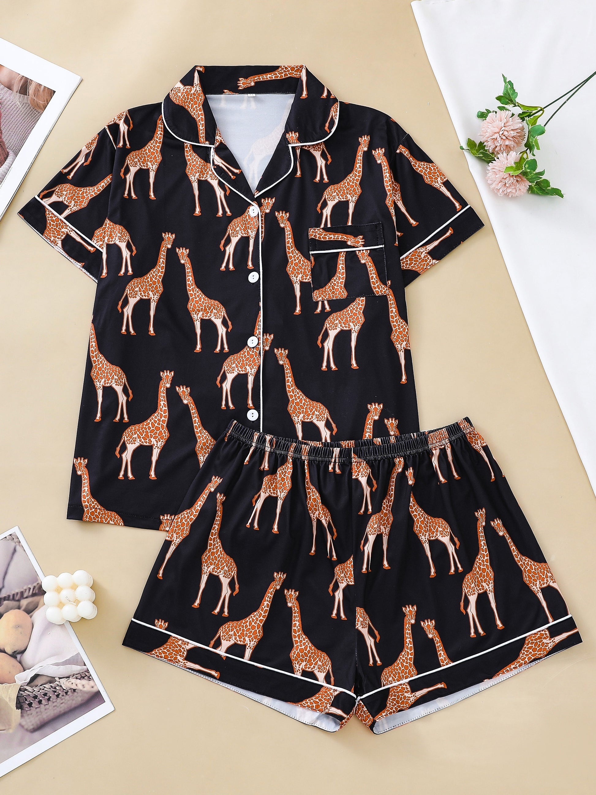 Hot satin-look pajama set with black-and-white giraffe print — short-sleeve button-up top with chest pocket and elastic waist shorts, 95% Polyester/5% Elastane