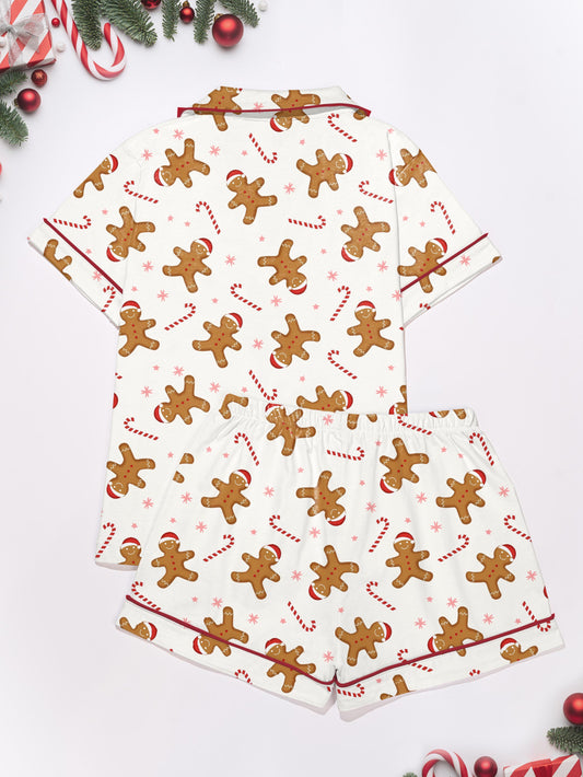 Pink holiday modal pajama set with gingerbread, candy cane and Santa print — short sleeve button top and elastic waist shorts with piping