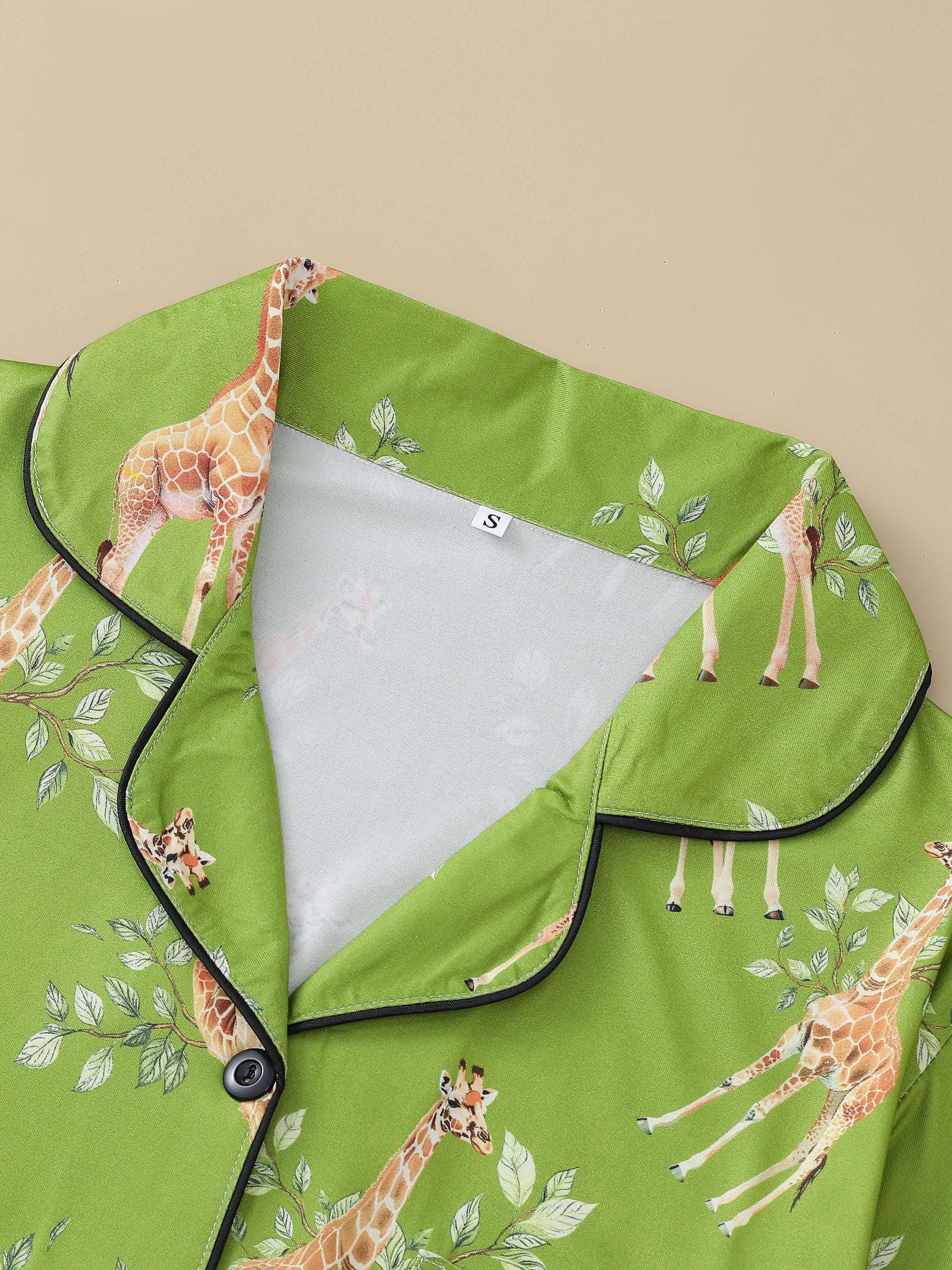 Cream satin-look pajama set with watercolor giraffe and green leaf print — short-sleeve button-up top with chest pocket and elastic waist shorts, 95% Polyester/5% Elastane