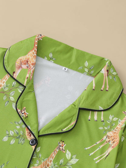 Cream satin-look pajama set with watercolor giraffe and green leaf print — short-sleeve button-up top with chest pocket and elastic waist shorts, 95% Polyester/5% Elastane