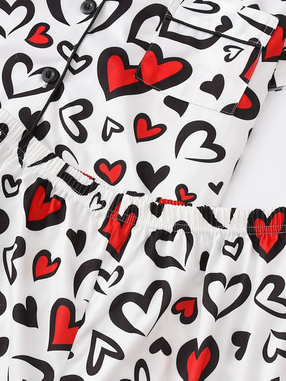 White satin-look short-sleeve pajama set with red and black heart print, piped trim, chest pocket and elastic waist shorts in 95% Polyester 5% Elastane — silky stretch travel-ready loungewear