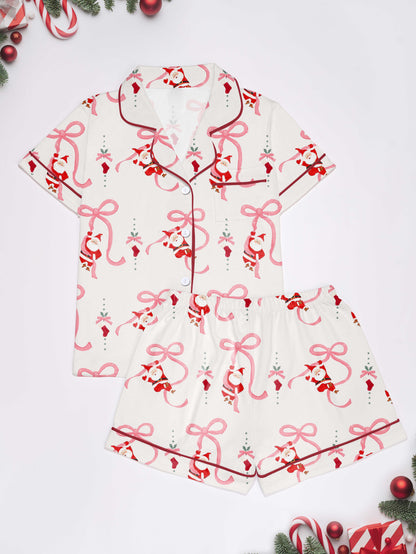 Cream modal pajama set with Santa and pink ribbon print — short‑sleeve button top and elastic waist shorts with pink piping