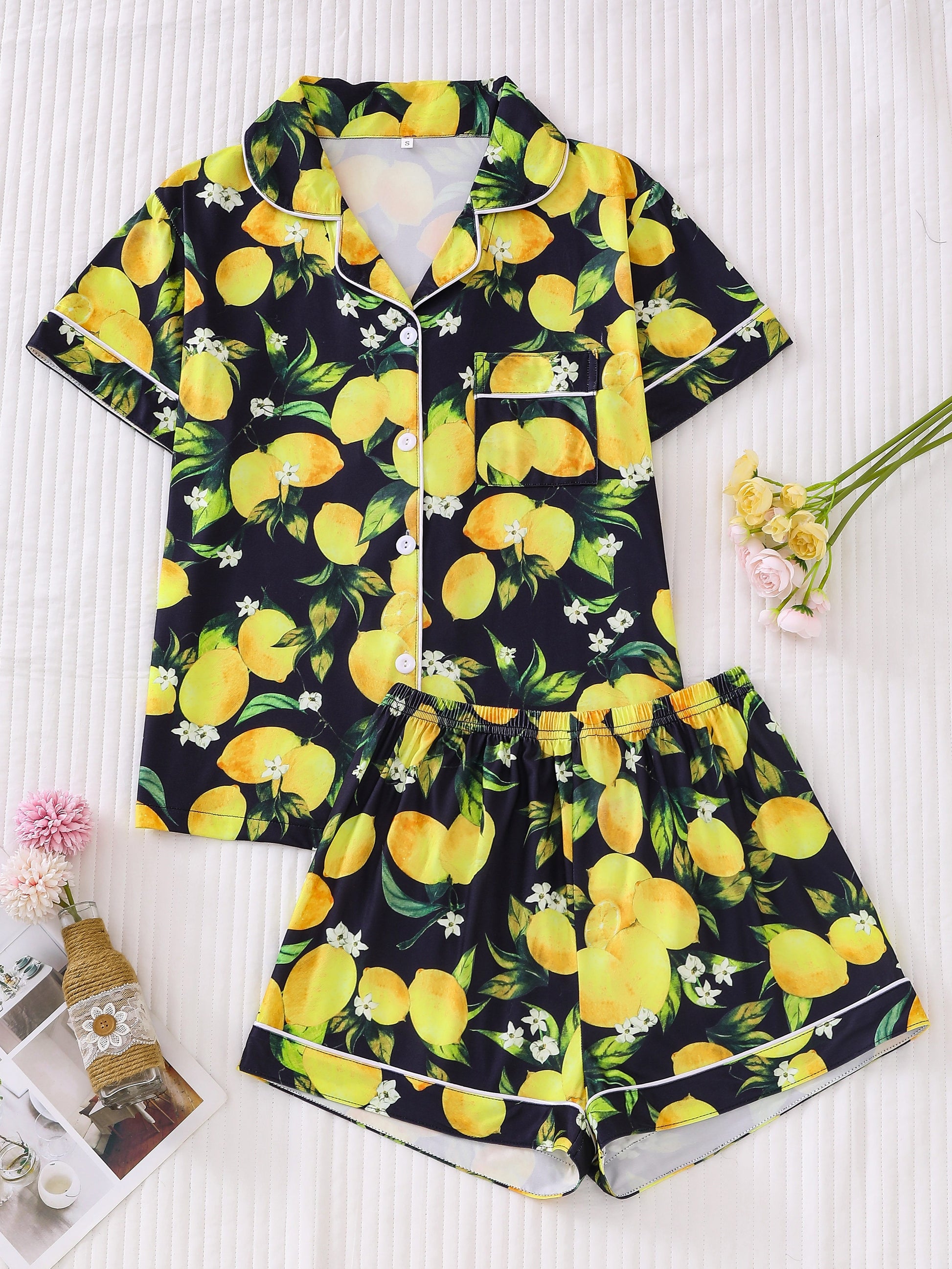 Navy satin-look short pajama set with bright watercolor lemon and green leaf print — short-sleeve relaxed top and elastic waist shorts, 95% Polyester/5% Elastane, lightweight and breathable