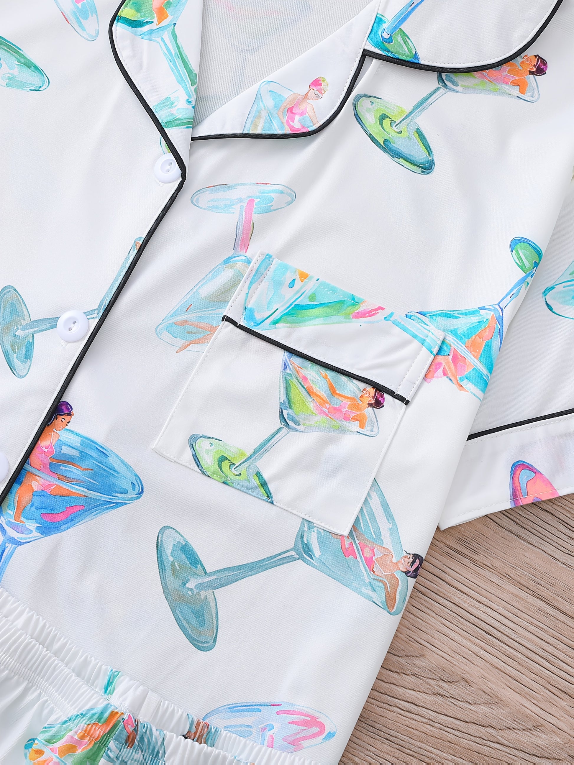 White satin-look pajama set with watercolor martini glass print, short-sleeve button top with piped pocket and elastic waist shorts — 95% Polyester/5% Elastane, silky and breathable