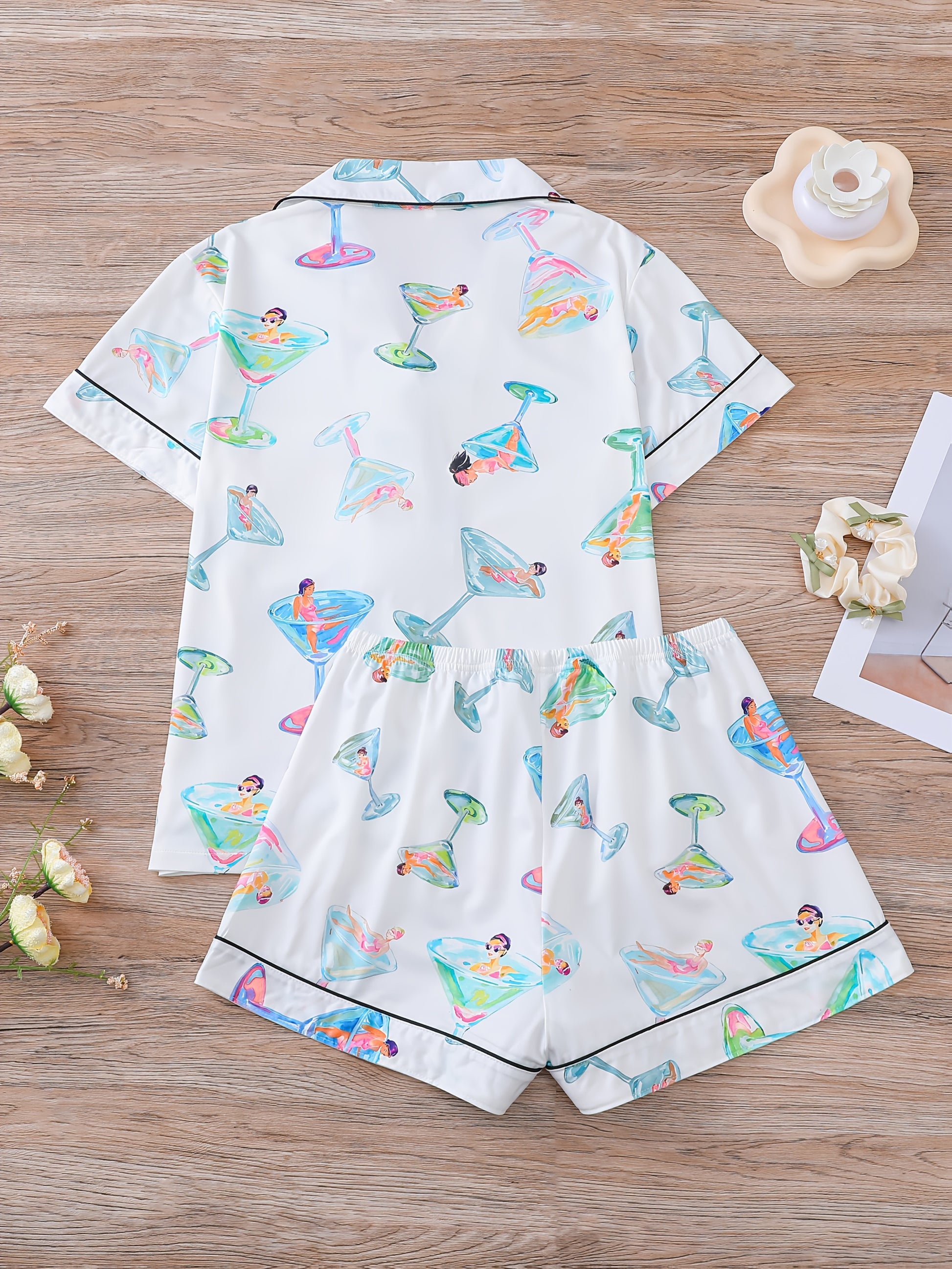 White satin-look pajama set with watercolor martini glass print, short-sleeve button top with piped pocket and elastic waist shorts — 95% Polyester/5% Elastane, silky and breathable