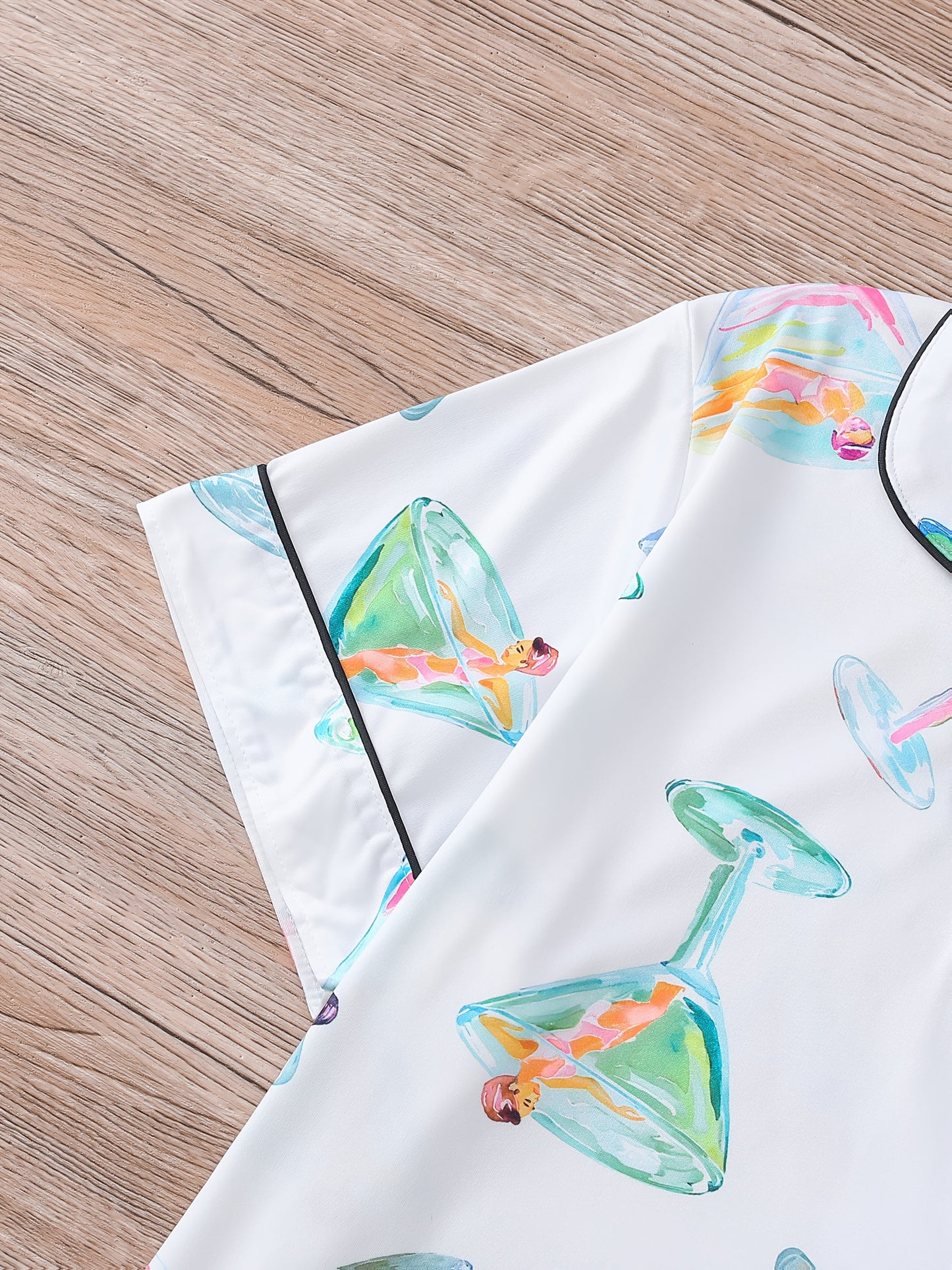 White satin-look pajama set with watercolor martini glass print, short-sleeve button top with piped pocket and elastic waist shorts — 95% Polyester/5% Elastane, silky and breathable