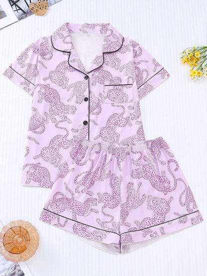 White satin-look pajama set with black cheetah print — short-sleeve button-up top with chest pocket and elastic waist shorts, 95% Polyester/5% Elastane