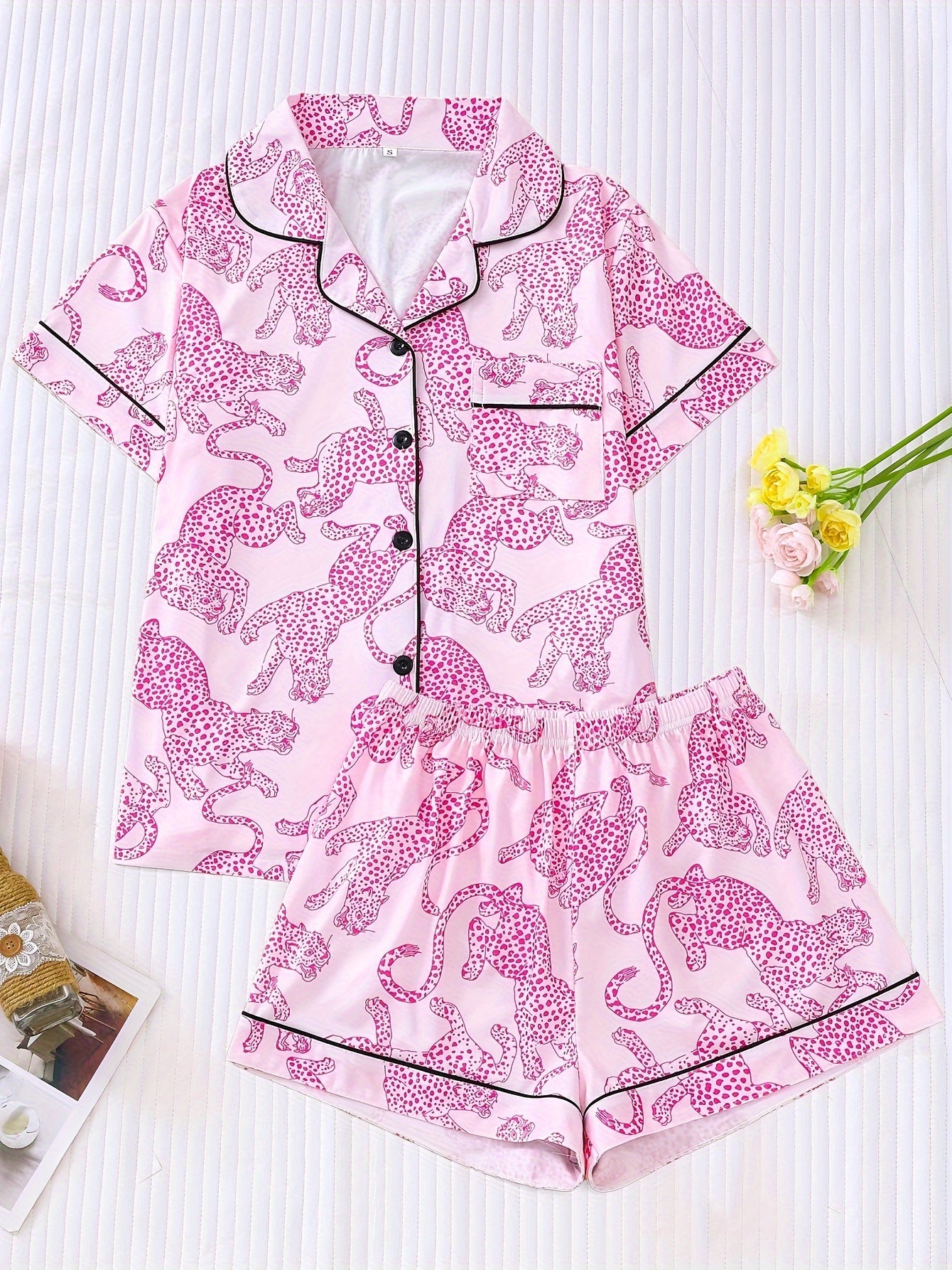 White satin-look pajama set with black cheetah print — short-sleeve button-up top with chest pocket and elastic waist shorts, 95% Polyester/5% Elastane