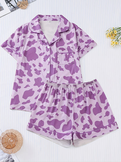 White silk‑touch modal short‑sleeve pajama top and elastic waist shorts with black cow‑spot print and aqua piping