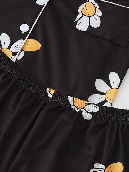 Black satin-look short-sleeve pajama set with white daisy print, piped trim, chest pocket and elastic waist shorts in 95% Polyester 5% Elastane — silky stretch loungewear