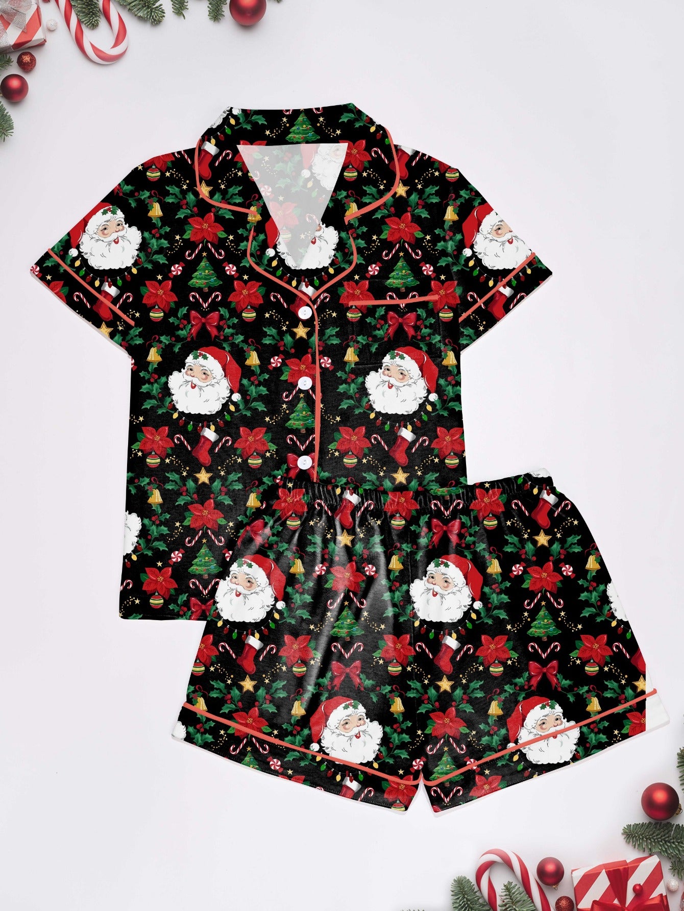 Woman wearing black short-sleeve pajama set with Santa, poinsettia and candy cane print — button-up top and elastic waist shorts with red piping