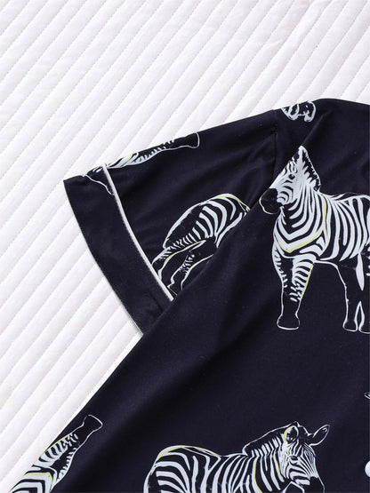 Navy satin-look short pajama set with black-and-white zebra print — short-sleeve button-up top and elastic waist shorts, 95% Polyester/5% Elastane, lightweight and silky