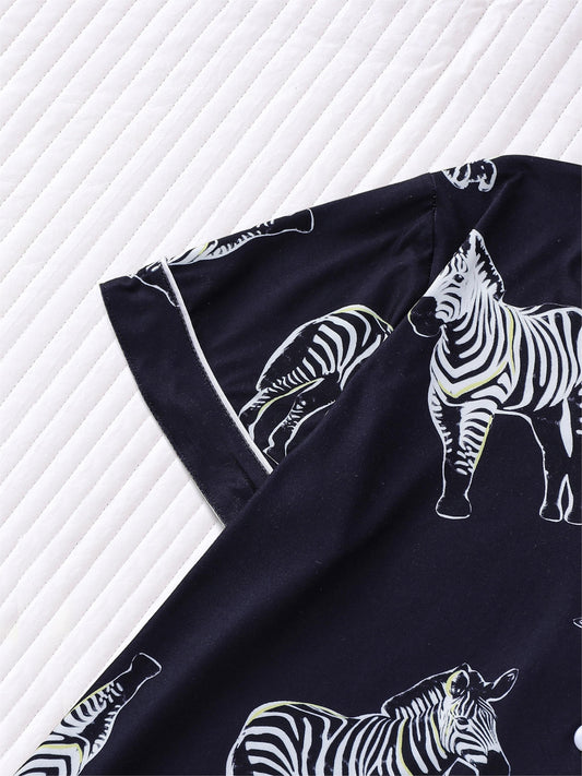 Navy satin-look short pajama set with black-and-white zebra print — short-sleeve button-up top and elastic waist shorts, 95% Polyester/5% Elastane, lightweight and silky