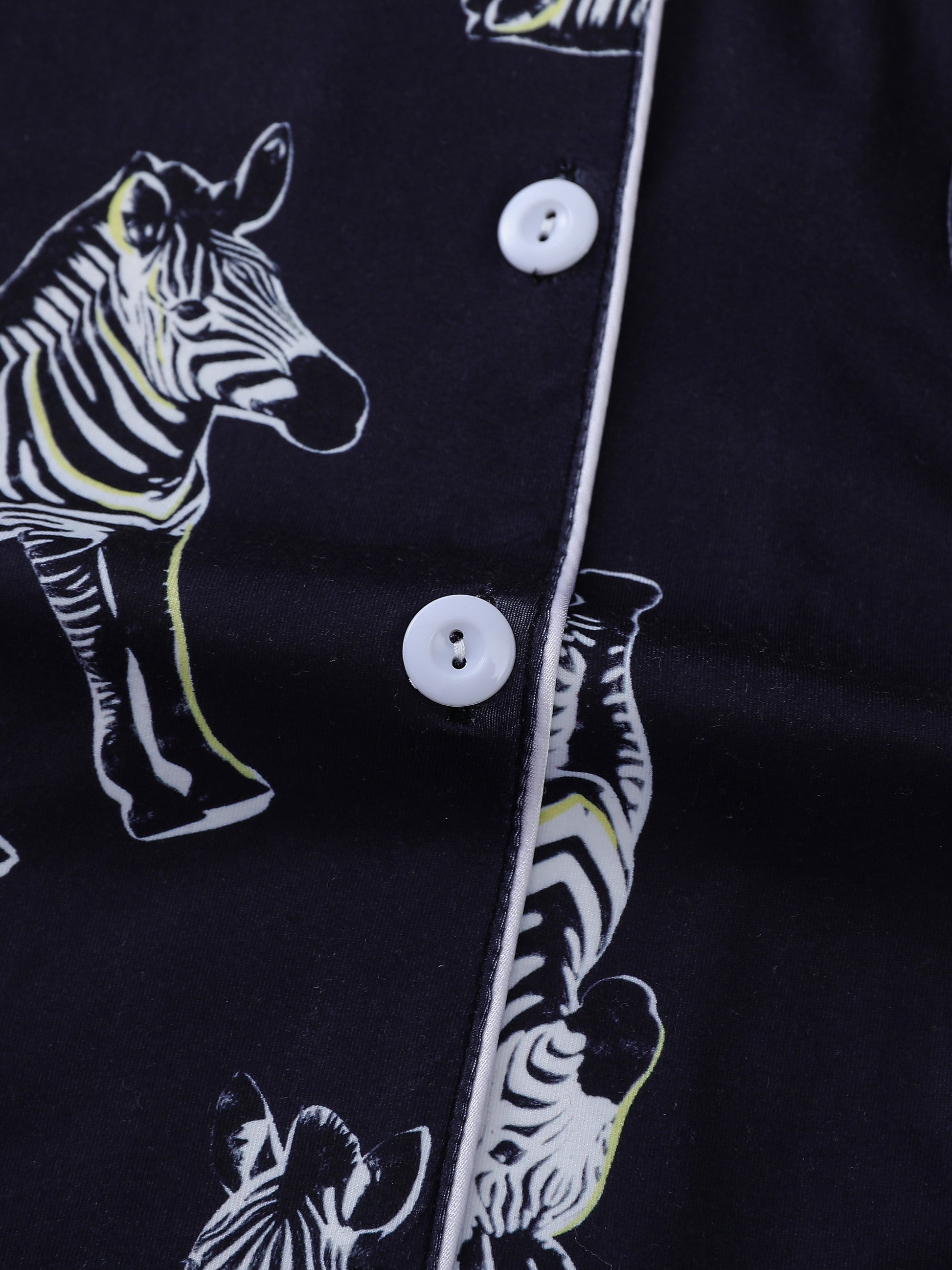 Navy satin-look short pajama set with black-and-white zebra print — short-sleeve button-up top and elastic waist shorts, 95% Polyester/5% Elastane, lightweight and silky