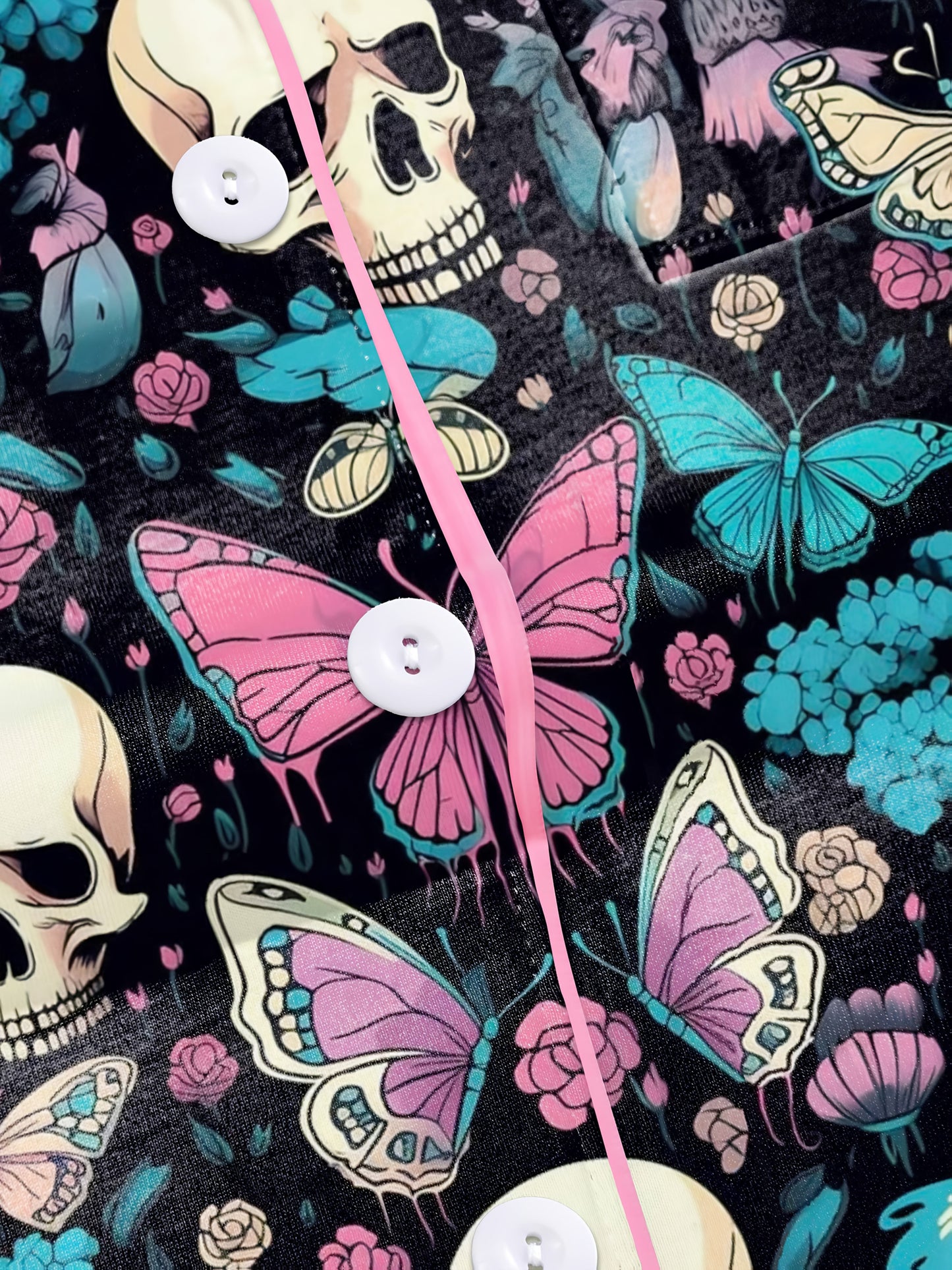 Black modal pajama set with cream skulls, pink and turquoise butterflies and floral accents — short sleeve button top and elastic waist shorts with piping