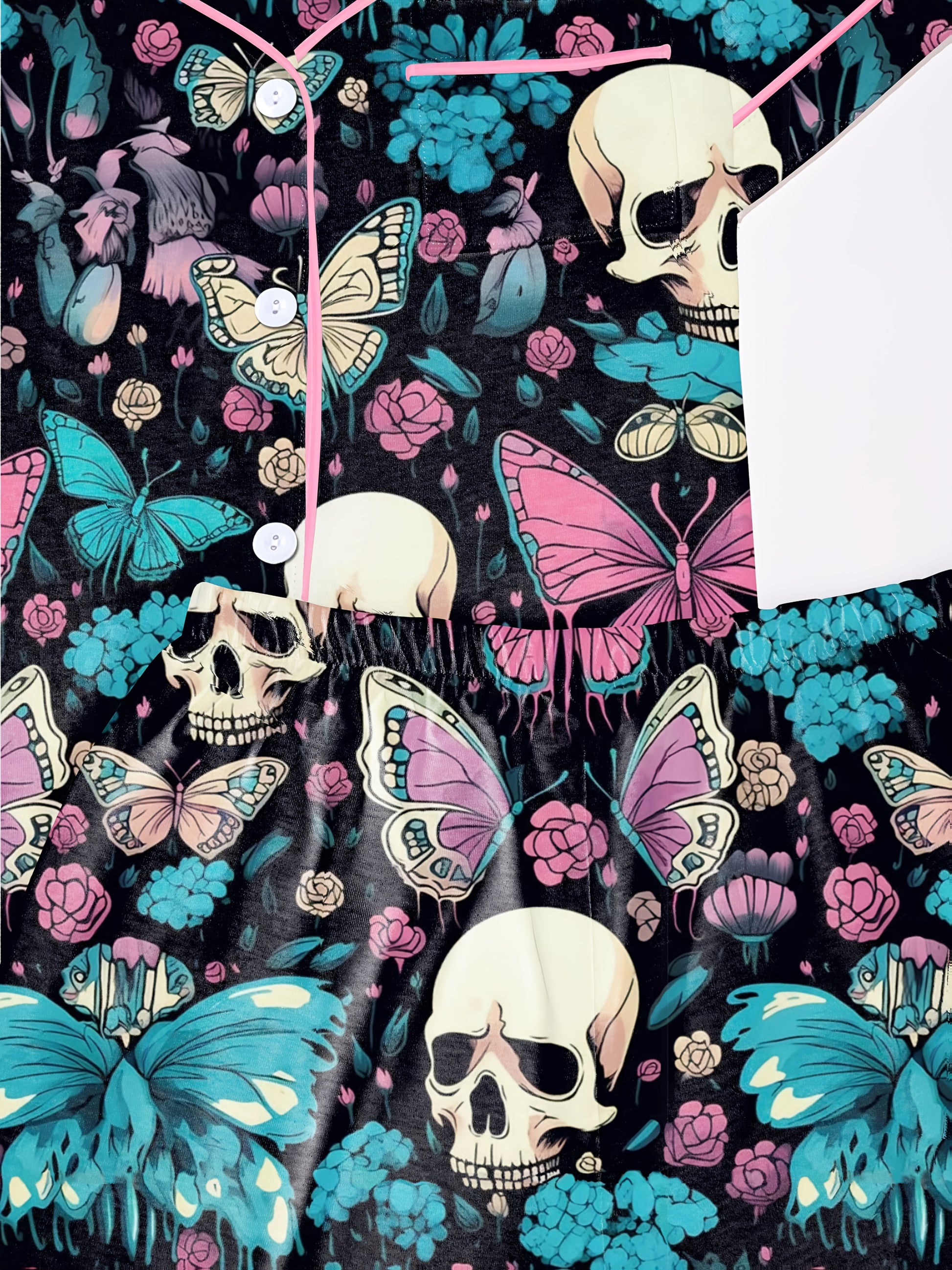 Black modal pajama set with cream skulls, pink and turquoise butterflies and floral accents — short sleeve button top and elastic waist shorts with piping